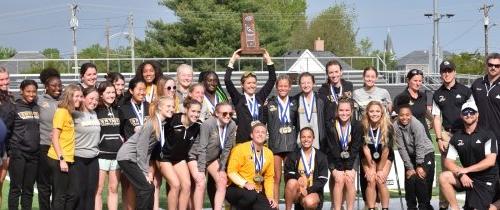 Large group of Women's Cross Country Team celebrating championship